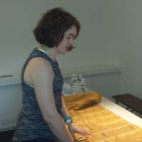 <p>ArtsWestchester Gallery Director Kathleen Reckling shows a piece of fabric used in an interactive display that changes color when touched by visitors. The &quot;SHE: Deconstructing Female Identity&quot; exhibit is on display in White Plains through June 25.</p>