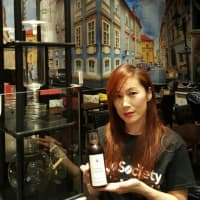 <p>Owner Cherie Ryu holds a bottle of cold brew at Kudo Society Cafe in Palisades Park.</p>