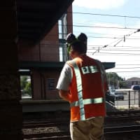 <p>A Metro-North railroad employee putting yellow paint near a platform warning sign in Rye on Friday.</p>
