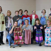 <p>Liz Skarzynski (kneeling, left) organizes and hosts sewathons for Dress A Girl Around The World.</p>