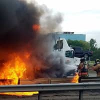 <p>Firefighters battle the flames consuming the tractor-trailer.</p>