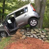 <p>An SUV ends up balanced on a stone wall after a crash on Thompson Street in Shelton on Thursday.</p>