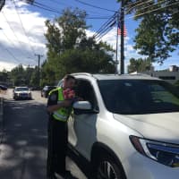 <p>Wilton police officers hand out pink roses as part of a campaign of random acts of kindness.</p>