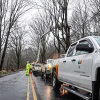 <p>United Illuminating trucks positioned along Main Street in Hamden while crews repair overhead electrical wires after trees fell on the wires on Friday.</p>
