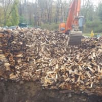 <p>Metro-North crews work to clear a massive woodpile from the tracks in Wilton along the Danbury Branch on Monday.</p>