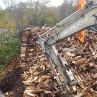 <p>Metro-North crews work to clear a massive woodpile from the tracks in Wilton along the Danbury Branch on Monday.</p>