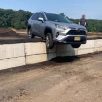 <p>A driver was rescued from a vehicle that was teetering over the edge of a barrier wall in Morris County Tuesday morning, authorities said.</p>