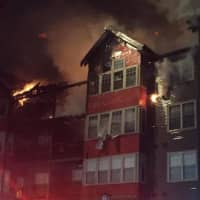 <p>Extensive damage can be seen as the condo building burns on Monday evening in Norwalk.</p>