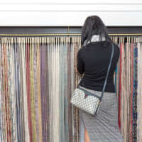 <p>A customer looks through fabrics at Togas in Greenwich.</p>