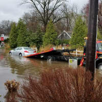 <p>The driver of an Acura sedan became trapped in her vehicle after driving around barricades and into a flooded street Monday.</p>