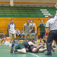 <p>Coach Job Fernandez (in white) urges on his wrestler.  He hopes the mattress fundraiser will help the team  buy new team jackets and other necessities.</p>