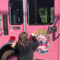 <p>AnnMarie Carrier adds her name to the Pink Heals firetruck.</p>
