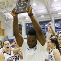 <p>Bethel High School girls basketball coach Anderson Rawlins celebrates with the championship trophy.</p>