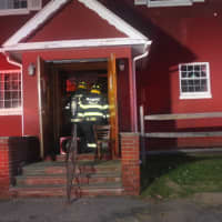<p>Firefighters Lou Scagnelli and Ann Link set up a smoke ejector in the front doorway.</p>