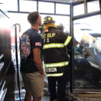 <p>Firefighters remove the building&#x27;s storefront.</p>
