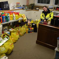 <p>A Norwood EMS member sits next to part of the organization&#x27;s haul of donations.</p>