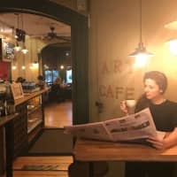 <p>A customer at Art Cafe of Nyack finds a quiet spot to read a newspaper and enjoy some coffee.</p>