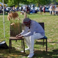 <p>Karl Scott adorns a chair with wild grasses at last year&#x27;s Art in the Park in Piermont.</p>