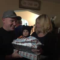 <p>Baby Jackson opens gifts from Santa, as Detective David Boone, and his elves.</p>