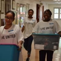 <p>United Way volunteers transporting bins filled with school supplies for children in need at KT Murphy Elementary School in Stamford.</p>