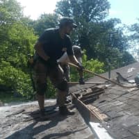 <p>Manuel Rodriguez works to replace the roof of a West Milford home.</p>