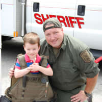 <p>A boy tries on a sheriff&#x27;s vest during Kent Public Library&#x27;s &quot;Big Truck and Community Vehicle Day&quot; on June 4.</p>