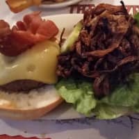 <p>The Celsus Burger served at North Salem&#x27;s The Blazer Pub is topped with melted Swiss cheese and bacon.</p>