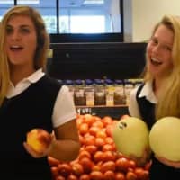 <p>Lauralton Hall High School students Elizabeth Garfield, of Milford, and Milly Koch, of Trumbull, use fruit props as part of “The Boob Song” video they created to encourage breast health.</p>