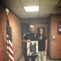<p>Artist Rachael Chandler presents Brookfield police Officer Jeffrey Osuch with a painting of his late K-9 partner, Bruno.</p>