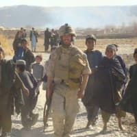 <p>Thomas Burke is shown in Helmand Province in Afghanistan. Many of the children shown tagging along with him were killed when they found an unexploded rocket-propelled grenade in their village, he says.</p>