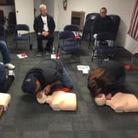 <p>performing CPR</p>