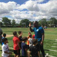 <p>Miami Dolphins receiver Leonte Caroo high-fiving campers</p>
