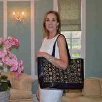 <p>Cathy Zahn of Franklin Lakes shows off models one of her bags.</p>