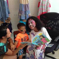<p>Chloe reads from her book &quot;PCD Has Nothing on Me&quot; to another child.</p>