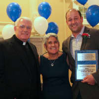 <p>Msg. Emmet Nevin, pastor, St. Aedan, in Congers with Martha Robles, executive director of Catholic Charities Community Services of Rockland, present Scott Curti of Curti’s Landscaping with the Business Community Service Award.</p>