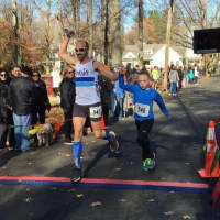<p>Jason Timochko crosses the finish line with his son, Ivan, who asked to run alongside him after completing the Boston Marathon this year.</p>