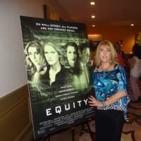 <p>Mahwah resident Suzanne Curry next to poster of &quot;Equity,&quot; which she co-produced.</p>