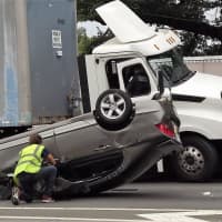 <p>The tractor-trailer mounted the divider, sending a chunk of concrete into a car on the southbound side.</p>