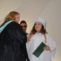 <p>A newly minted Webutuck High School graduate receives her diploma.</p>