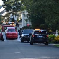 <p>A car is towed after a police pursuit ended Sunday in Southport.</p>