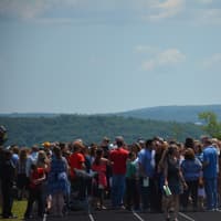 <p>Attendees gather outside of Webutuck High School&#x27;s commencement tent following the completion of the ceremony. The scenic landscape in Amenia can be seen in the background.</p>