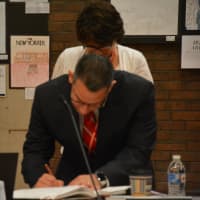 <p>Christopher Manno signs the paperwork that makes official his tenure as Bedford Central&#x27;s schools superintendent.</p>
