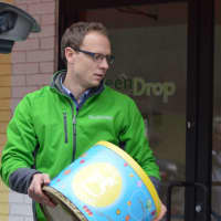 <p>GreenDrop General Manager Jason Coss collects household items for charity Friday.</p>