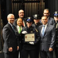 <p>White Plains Police Officer Amy Carelli, center, received her Police Academy training certificate from Commissioner David E. Chong (left of her) and was joined on stage by several family members who also are serving or retired as police officers.</p>