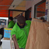 <p>An employee at GreenDrop collects household items for charity Friday.</p>