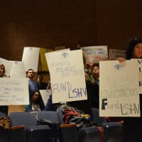 <p>Supporters of Legal Services of the Hudson Valley hold up signs at a Westchester County budget hearing.</p>