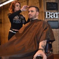 <p>Christine Modica cuts Jordan Galbraith&#x27;s hair as he sips whiskey at Stag House in Glen Rock.</p>