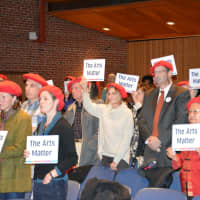 <p>Opponents of a proposed cut in arts funding for the 2016 Westchester County budget attend a hearing with red berets and signs.</p>