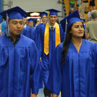 <p>Students enter the Abbott Tech High School graduation two by two.</p>