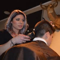 <p>Rachel Israel gives a young client a cut at Stag House in Glen Rock.</p>